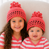 Older girl and baby wearing Coral crochet pom-pom beanies in coral. Digital pattern PDF, sizes Preemie to 10 Years.