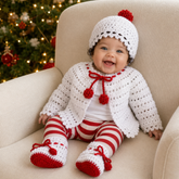 Baby wearing the white Holly Christmas crochet cardigan, matching hat with red pompom and booties. Digital PDF pattern set, 0–3 Months.