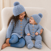 Girl and baby on a cream chair in Kasey crochet cardigans and hats; baby wears pants and booties. Digital pattern PDF set