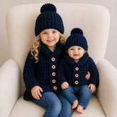 Child and baby wearing William navy crochet shawl-collar cardigans and pompom hats for a Preemie–10Y digital pattern PDF.