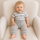Baby on a cream chair wearing Zac crochet pants. Digital pattern PDF, sizes Newborn to 2 Years.
