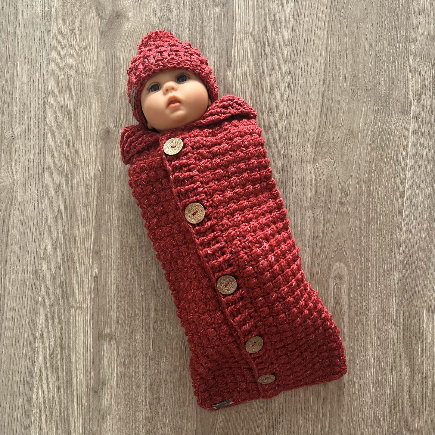 berri crochet sleeping bag and hat on baby arms in shawl collar down