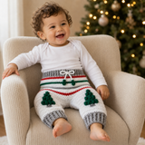 Baby wearing white Chrissy crochet pants with green Christmas tree motifs, red and green stripes and grey cuffs. Digital PDF pattern.