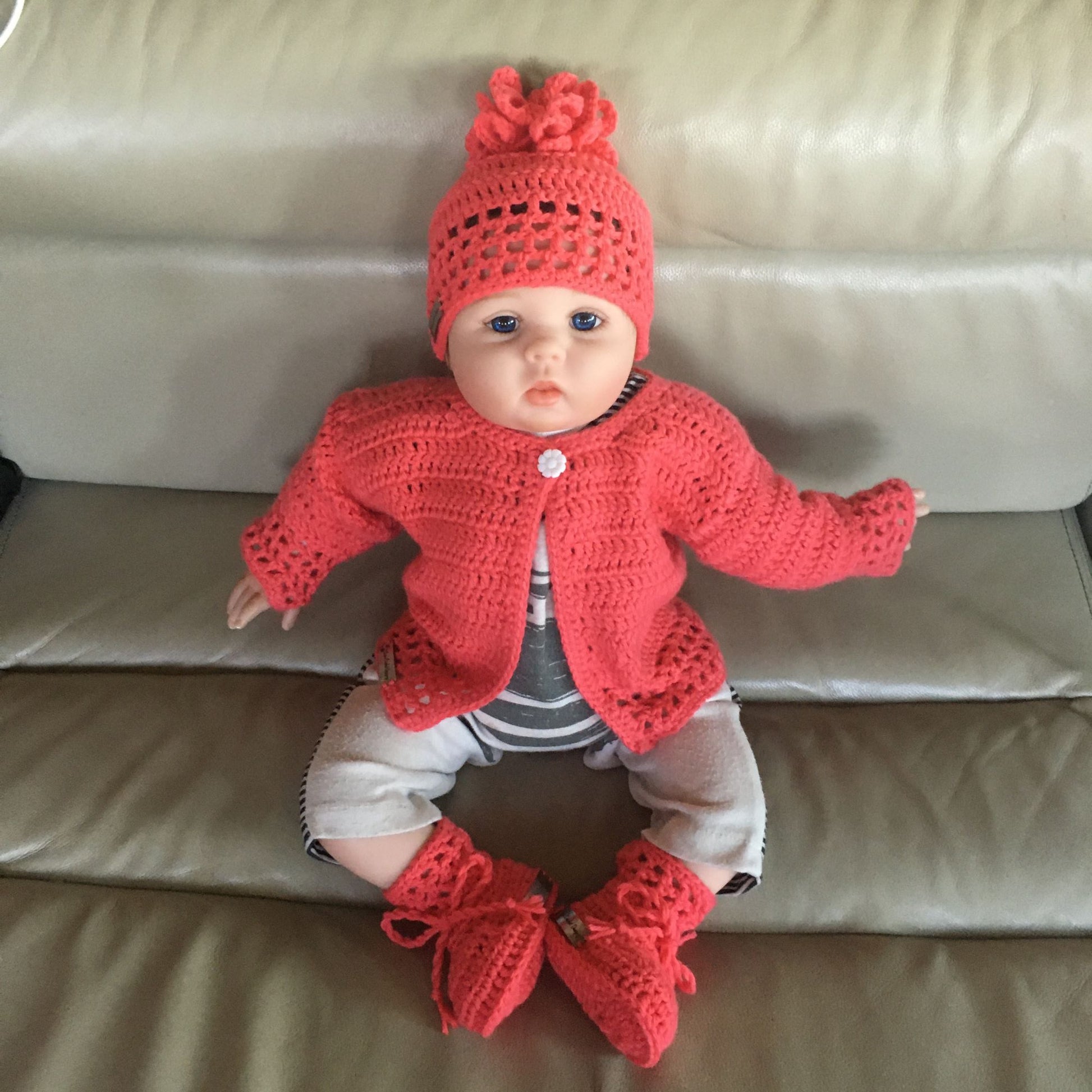 coral sweater hat and booties on baby