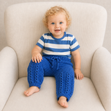 Baby wears blue Jacob crochet pants and blue-and-white T-shirt on a cream chair. Digital pattern PDF, NB to 2Y.