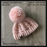 Light pink Lola cabled crochet hat flat lay on wood. Digital pattern PDF details, sizes Preemie to 10 Years
