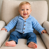 Baby in blue jeans wears a blue Luke crochet cardigan on a cream chair. Digital pattern PDF, size 0 to 3 Months.