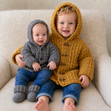 Boy in mustard Mason crochet hoodie sits with baby in brown hoodie and booties on a cream chair. Digital pattern PDF set.