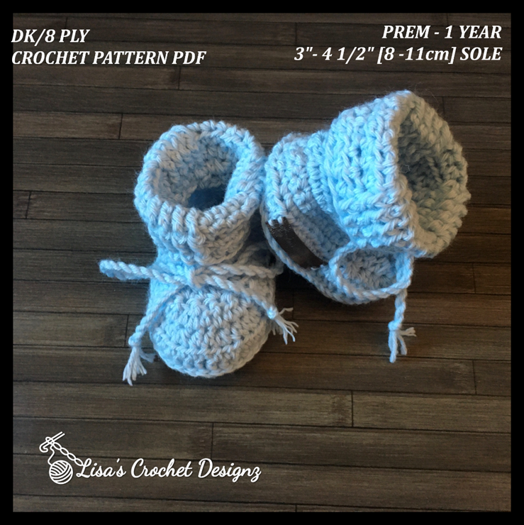 Zeb crochet baby booties flat lay on wood, showing digital pattern PDF details, sizes Preemie to 12 Months.