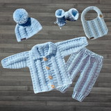 Zeb crochet cardigan, hat, booties, pants and bib flat lay on wood. Five-piece digital pattern PDF collection.