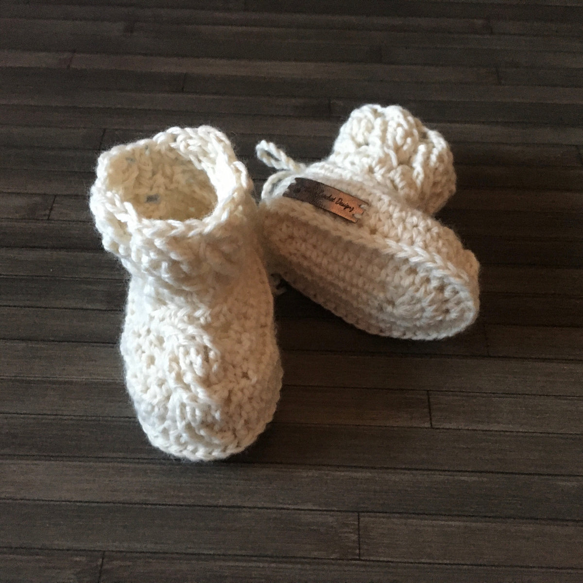 caleb crochet cabled baby booties one booty lying down